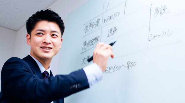 ホワイトボードの前で解説するコンサルタント