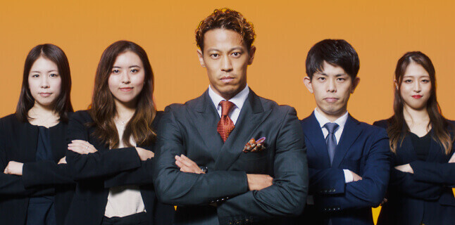 腕組みする本田圭佑とコンサルタント